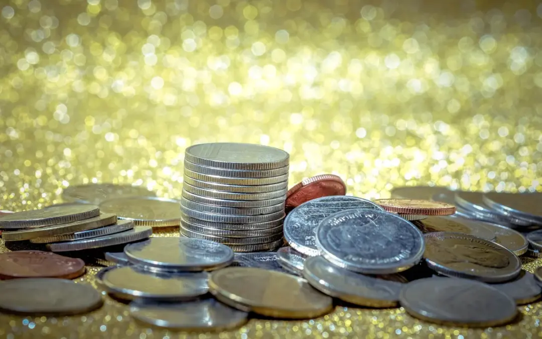 Close-up of various gold and silver coins on a table, highlighting the importance of careful evaluation.