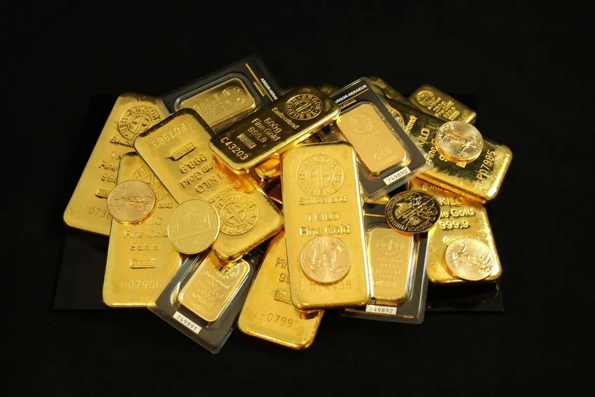 A collection of gold bars and coins representing investment and wealth, relevant to selling gold and silver.