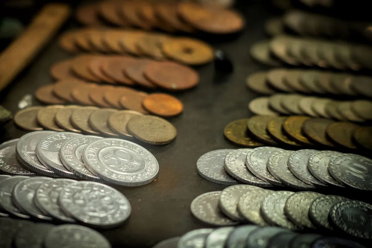 Close-up of vintage Indonesian coins showcasing different denominations and materials related to selling coins.