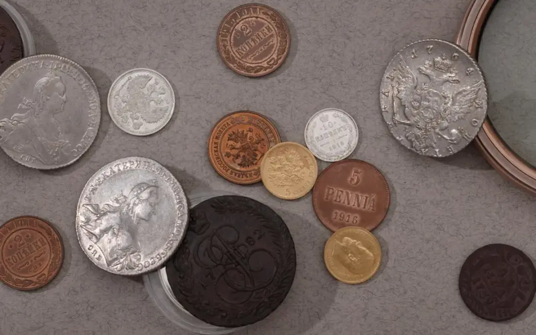 A collection of old collectible coins made of silver, gold, and copper on a table, reflecting numismatic interest.